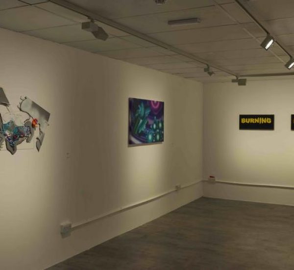 A gallery wall features a metallic abstract sculpture, a vibrant purple and green painting, and two black-and-yellow text pieces reading “Burning Bridges.”