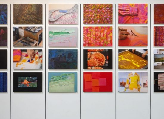 A gallery wall features a grid of vibrant photographs showing textiles, patterns, and studio processes in bright colours. To the right, a vertical row of stylised eye motifs in different colours is displayed.