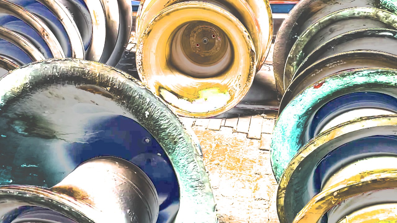 Abstract image showing a collection of large bells arranged in overlapping rows. The stylised treatment emphasises circular shapes, metallic surfaces and contrasting blue, green and gold tones.
